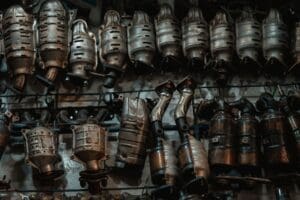 Mechanic replacing diesel particulate filter underneath a vehicle on a garage ramp