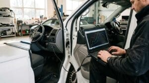Technician showing a customer a driveability tuning comparison on a tablet with smooth versus spiky response curves beside a Transit-style van